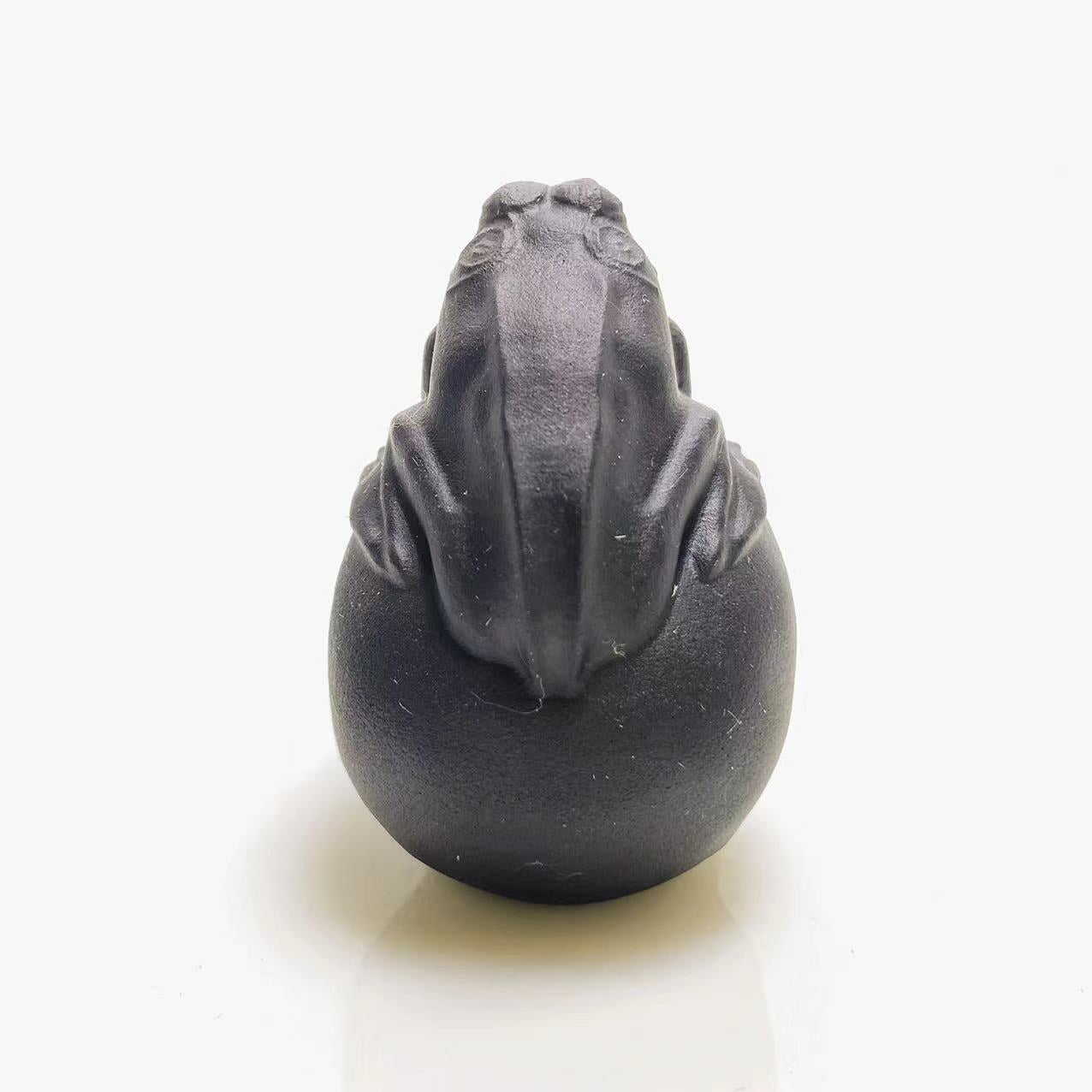 Black obsidian frog on skull carving