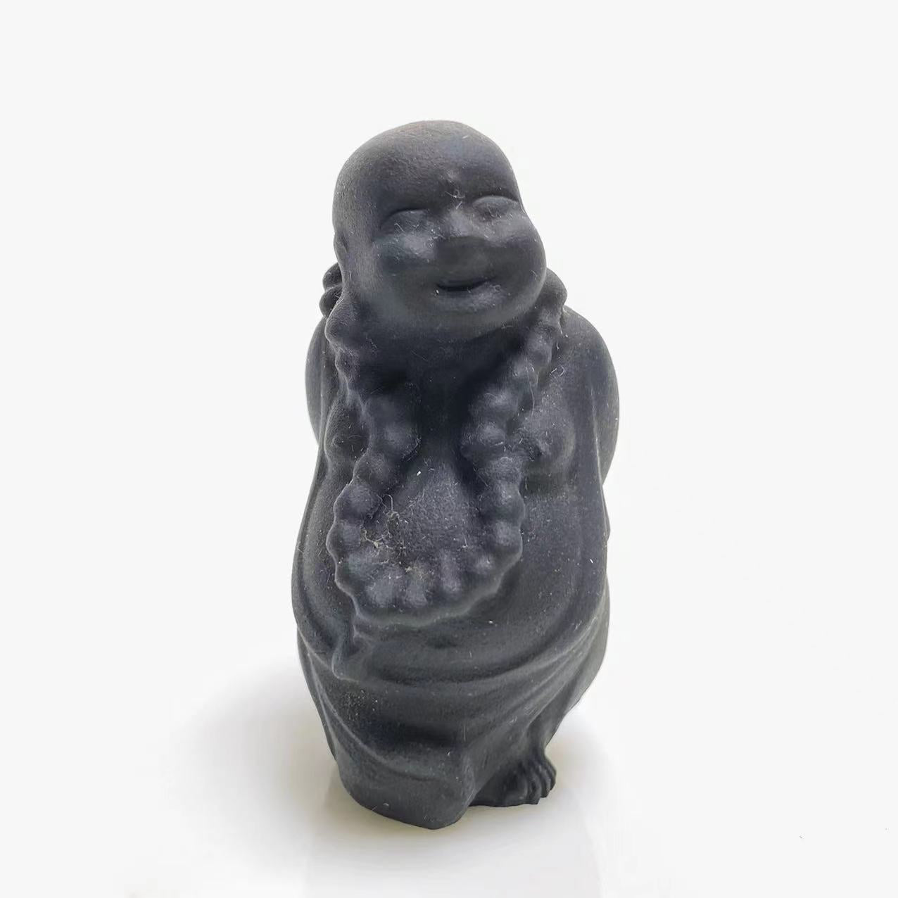 Black obsidian walking buddha carving