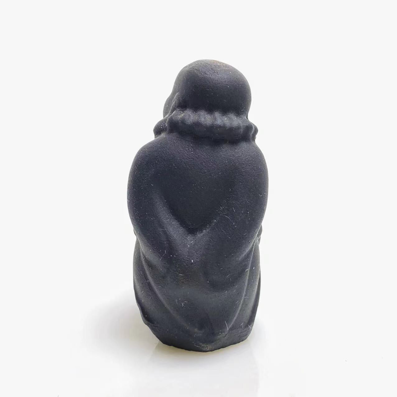 Black obsidian walking buddha carving