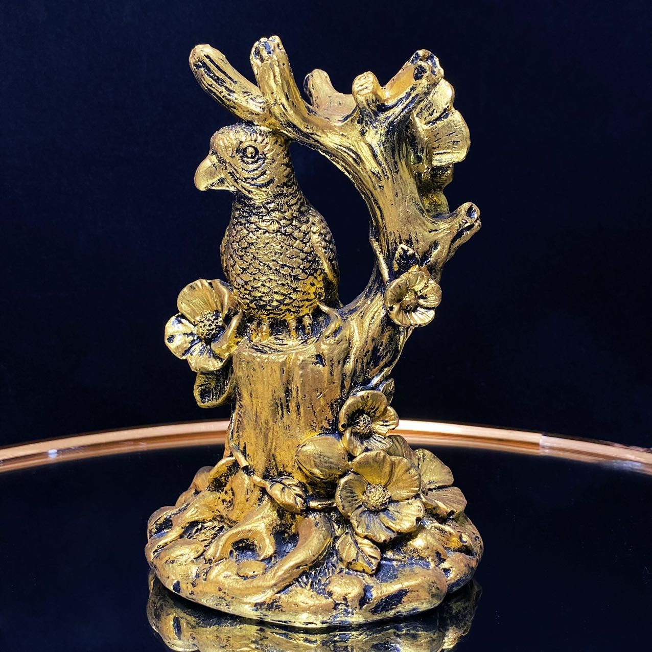 Resin parrot on the tree sphere stand