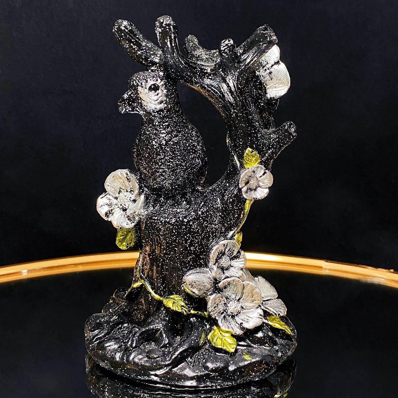 Resin parrot on the tree sphere stand