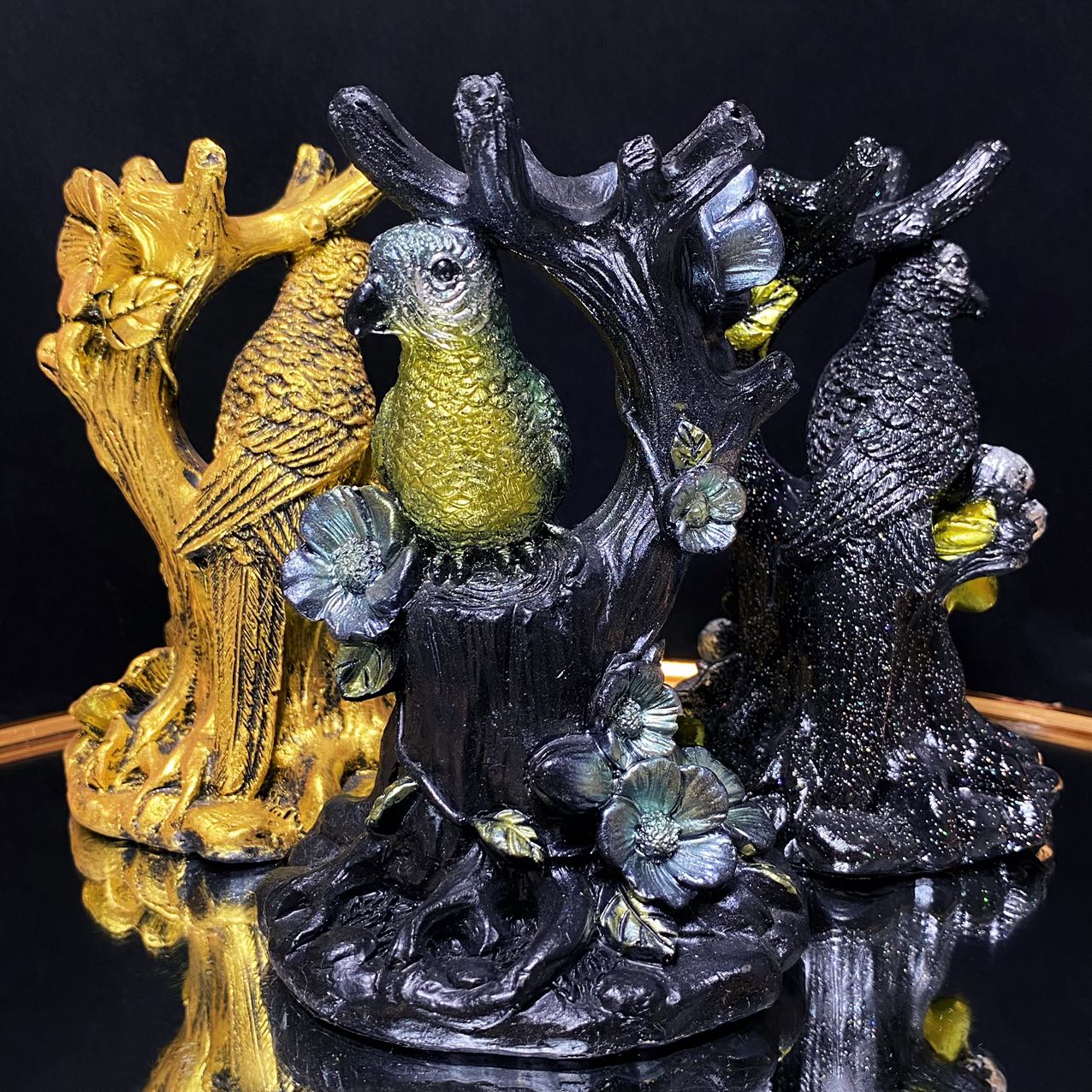 Resin parrot on the tree sphere stand