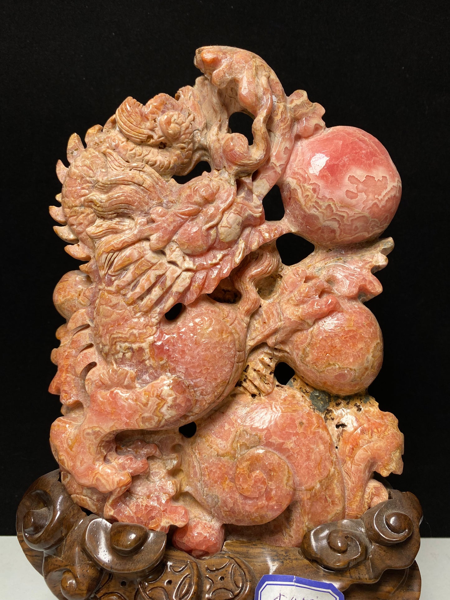Rhodochrosite Chinese dragon with sphere carving and wooden stand