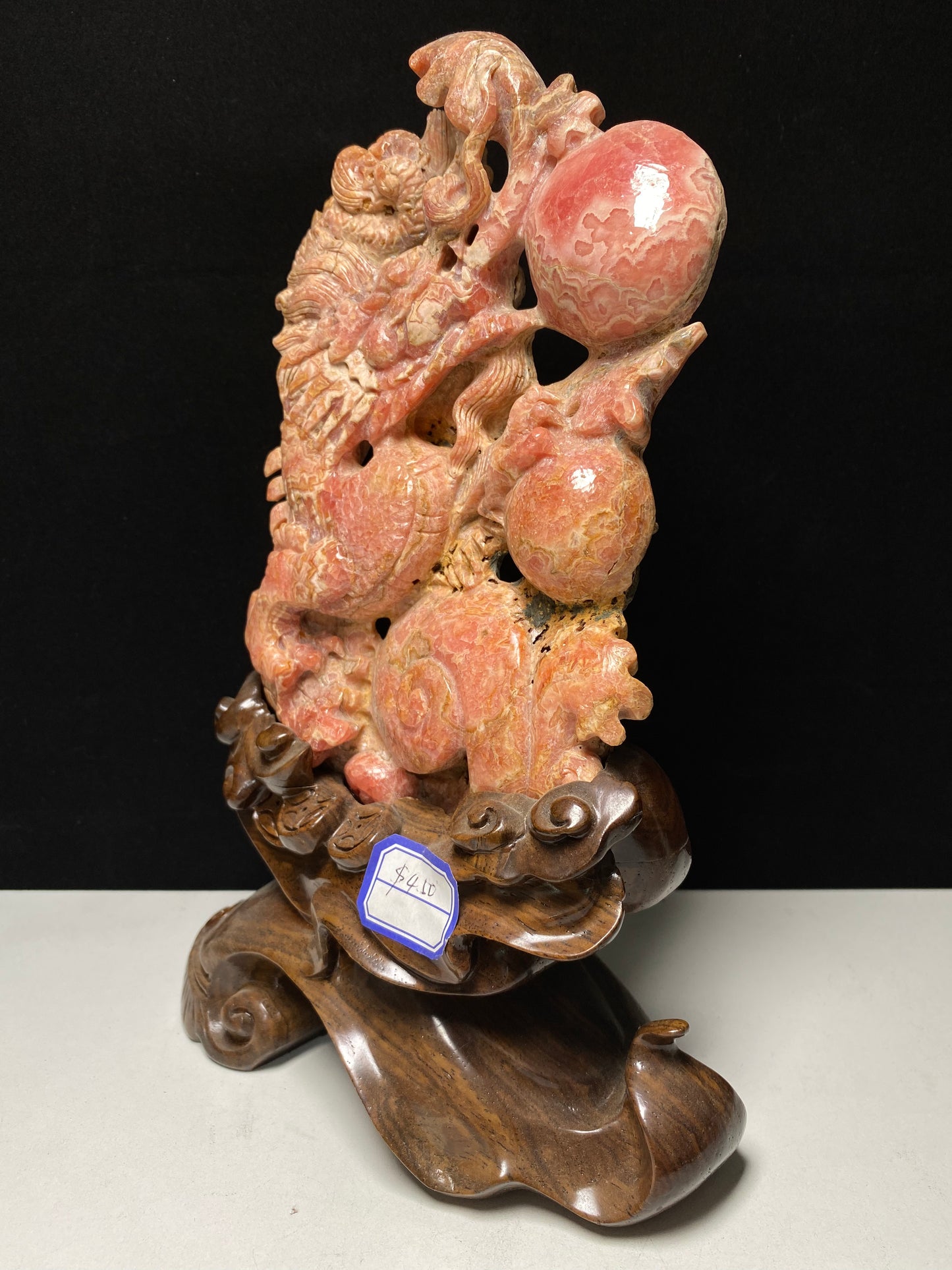 Rhodochrosite Chinese dragon with sphere carving and wooden stand