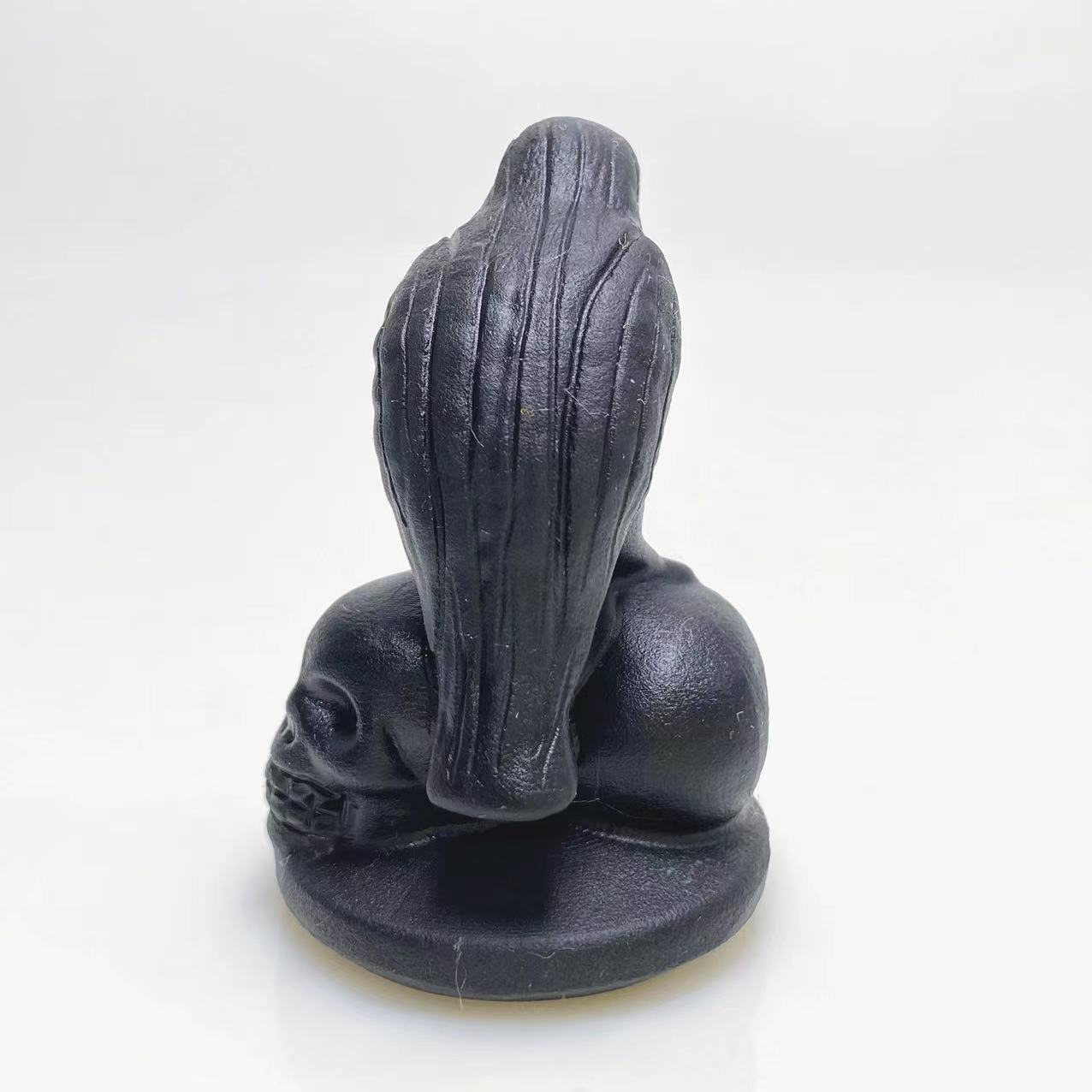 Black obsidian raven on skulls carving