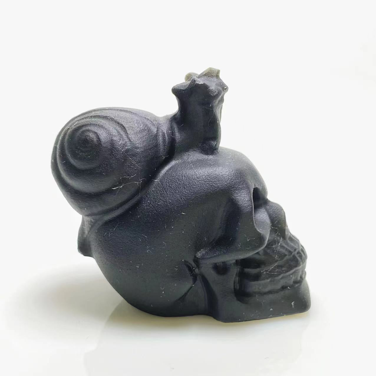 Black obsidian snail on skull carving