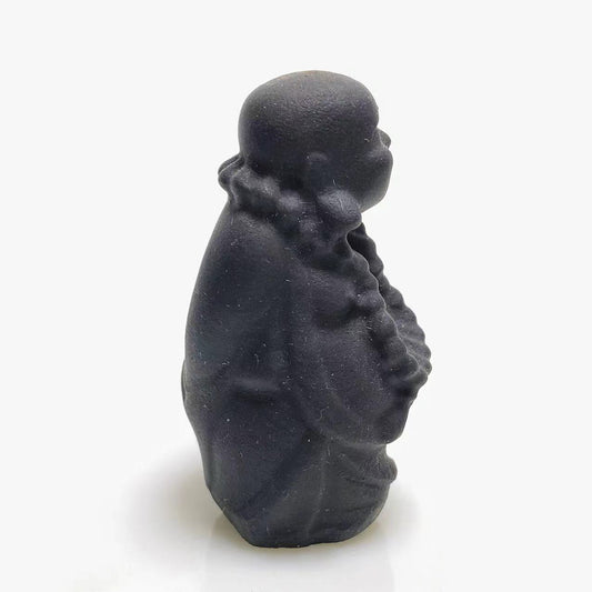Black obsidian walking buddha carving