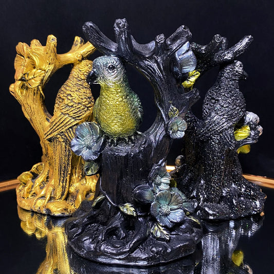 Resin parrot on the tree sphere stand